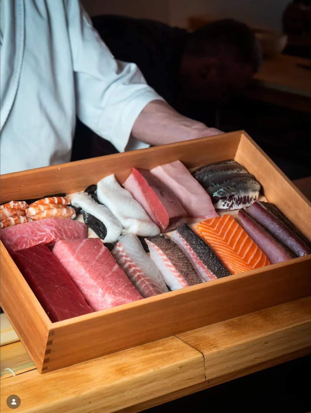 A cedar box of the day's fish presented at the counter.