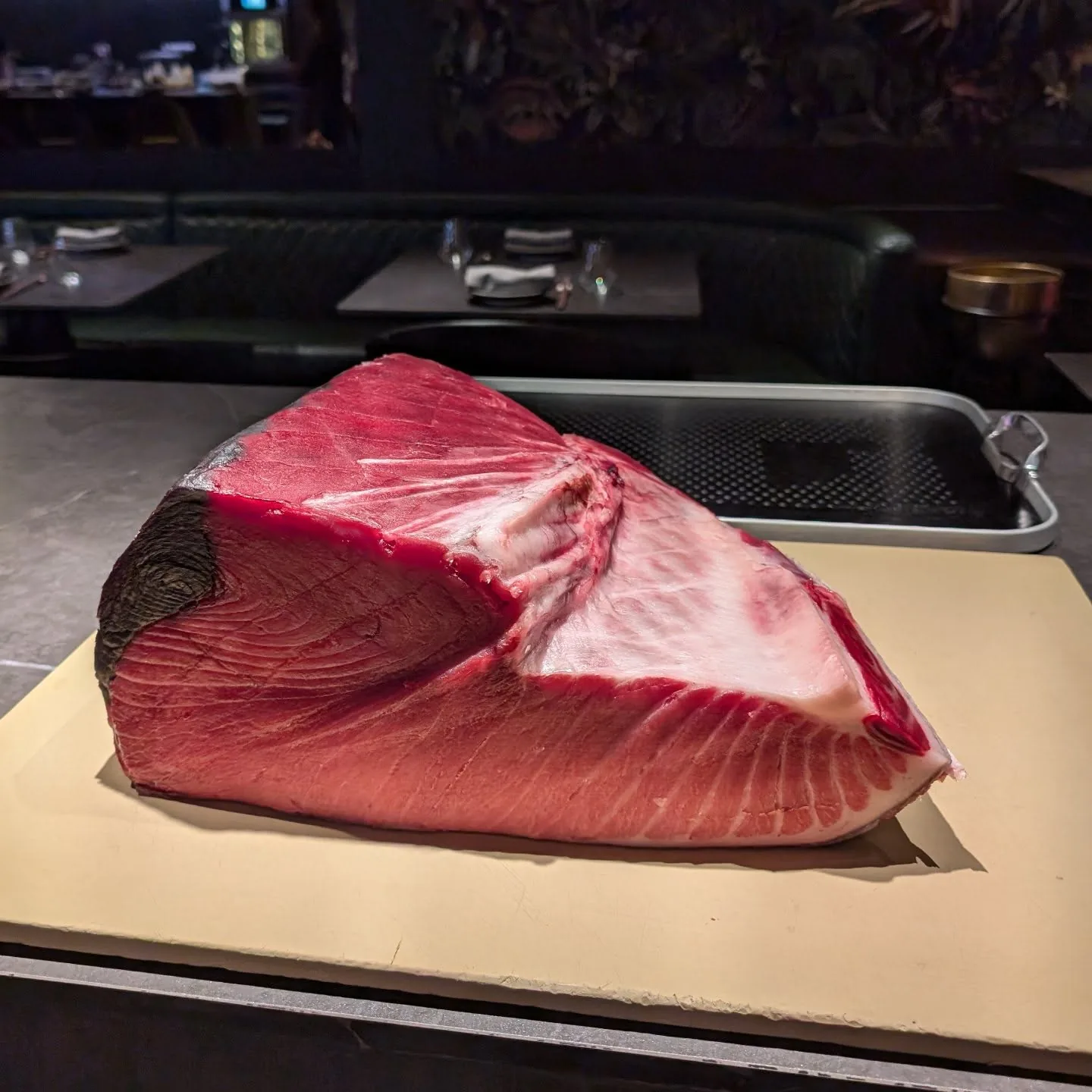 A block of bluefin tuna on the cutting board at the counter.